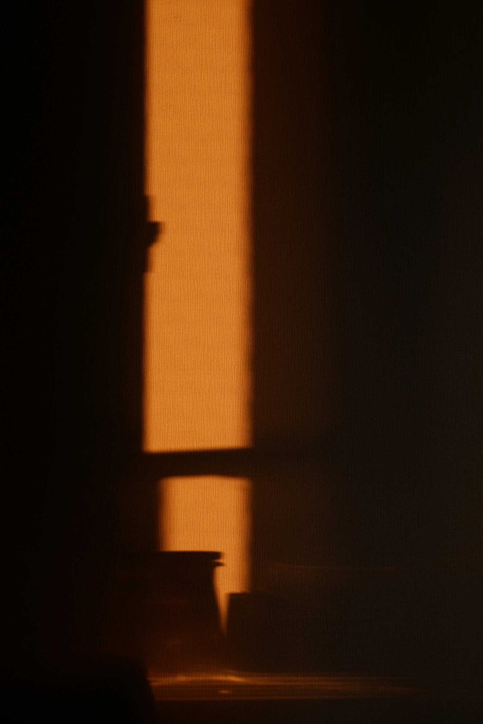 a wooden chair casts a shadow against the wall