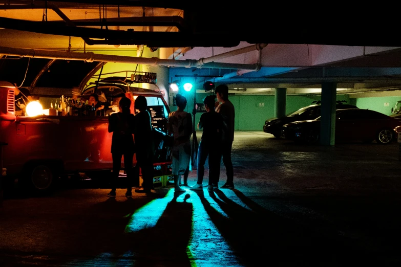 group of people standing under a green light