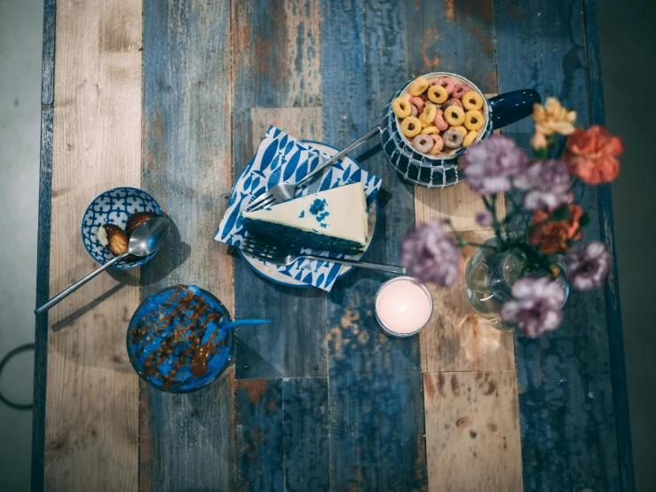 a table with two blue dishes of food and some cups