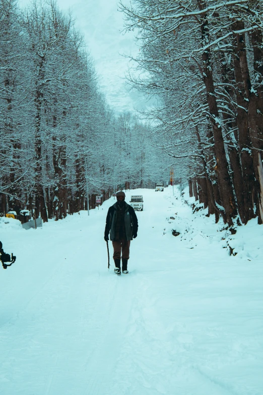 a man hiking up a snowy path on a snow covered path