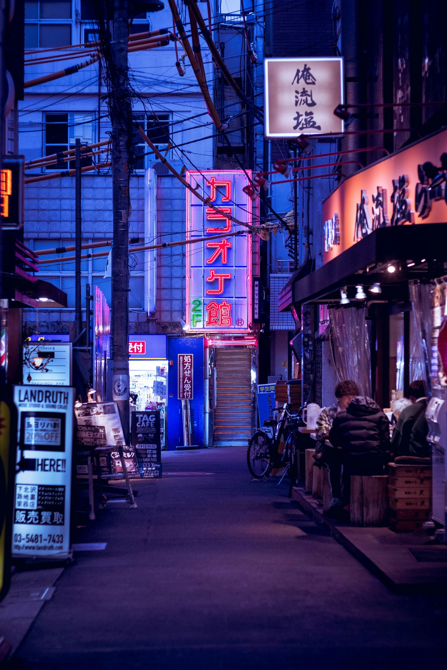 a long alley with many signs and people walking along the street