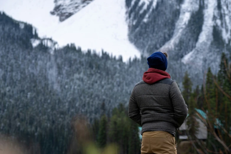 a man standing in front of a snowy mountain