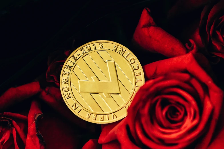 a gold token sitting on top of red roses