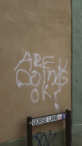 graffiti written on the side of a building in an alley