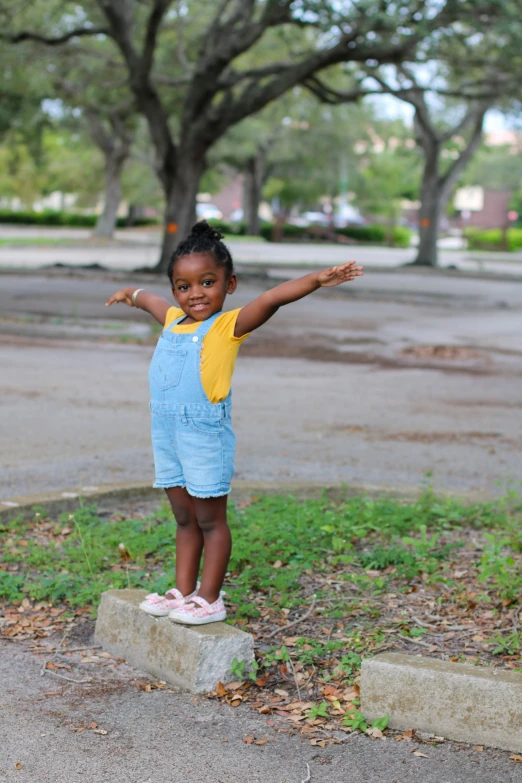 a little girl standing on top of some rocks