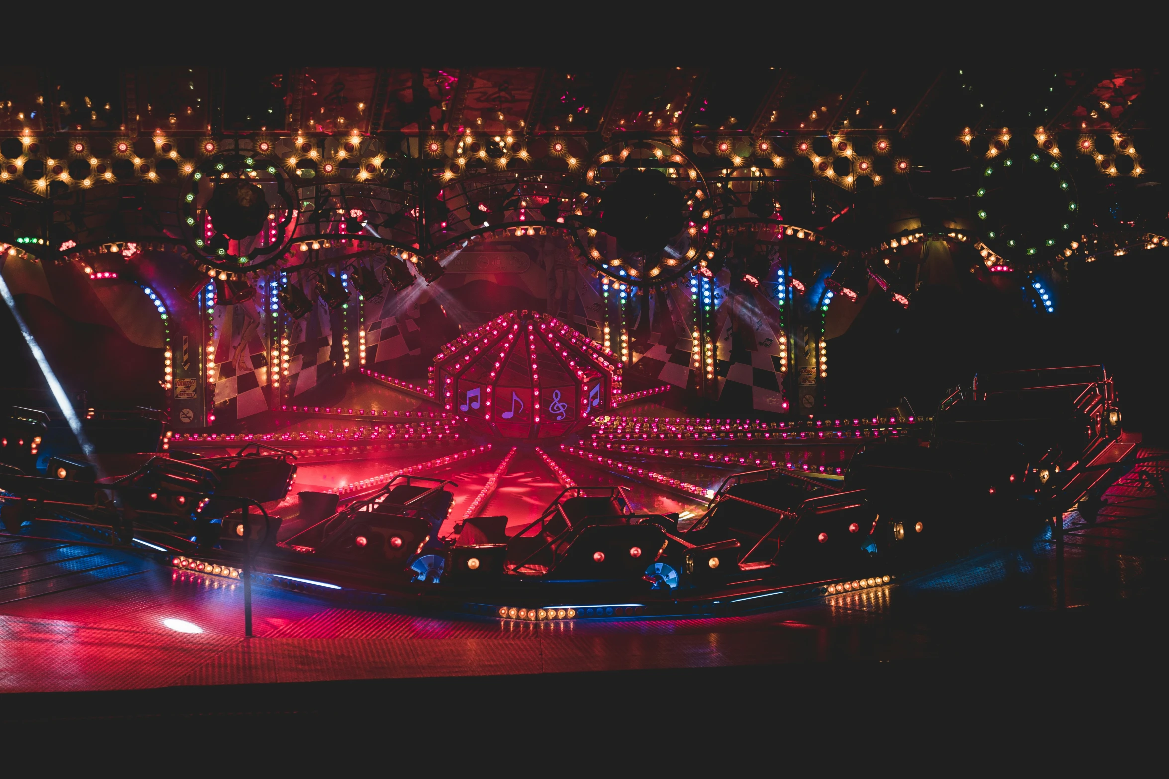 a lit carnival at night with multiple rides