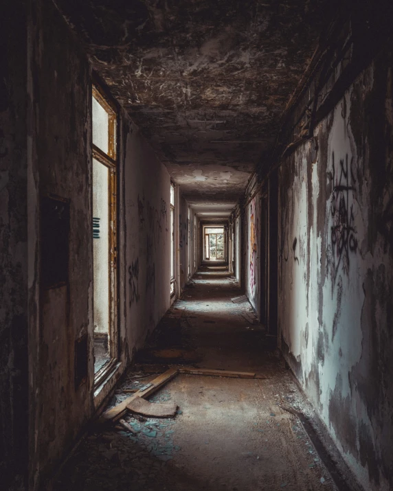 the hallway in an abandoned building with windows and graffiti