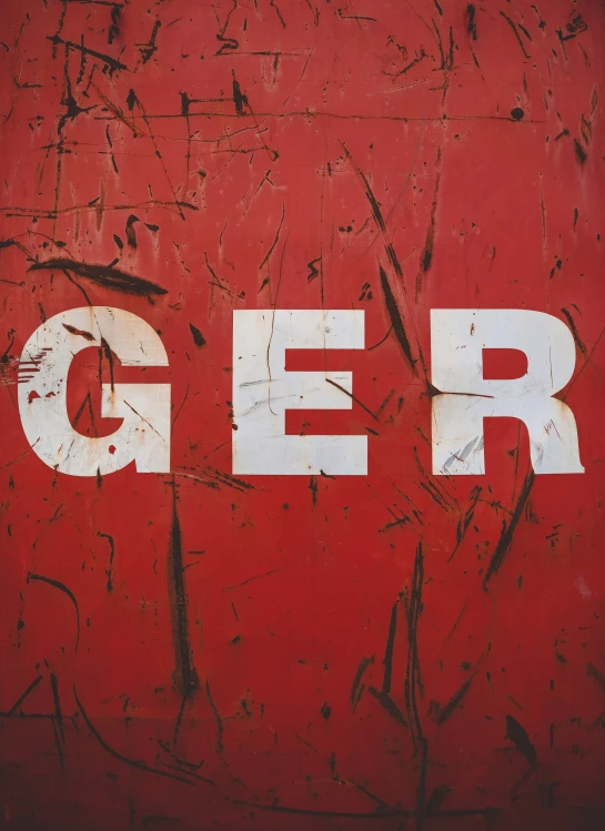 graffiti is posted on a red wall with the letters g e r