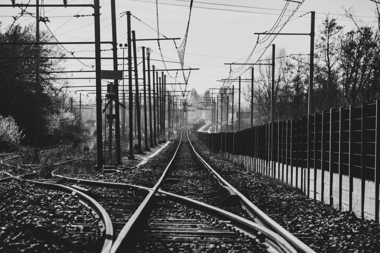 the railroad tracks have metal fencing around them