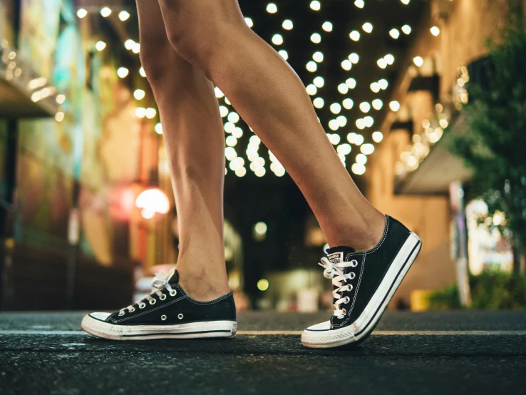 a close up of a person's legs with sneakers
