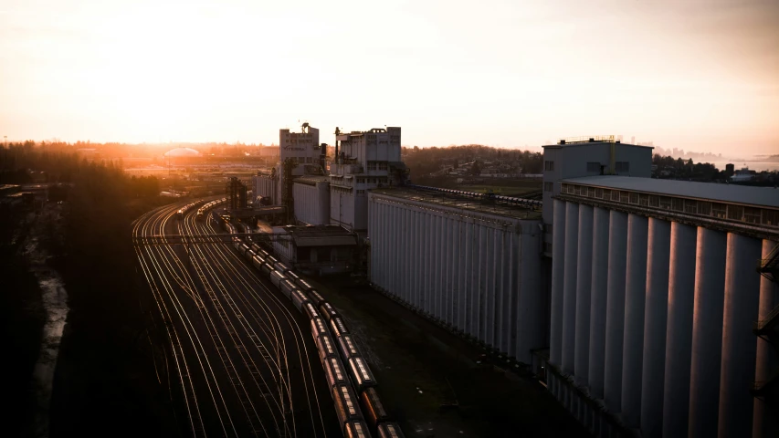 the sun setting over a train station and tracks