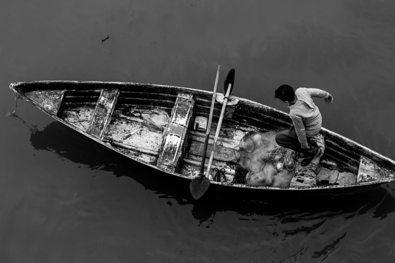 a man sitting in the bow of a boat with an umbrella