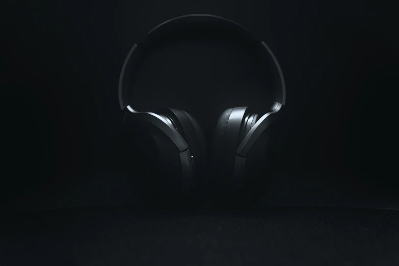 a pair of black headphones in front of a dark background