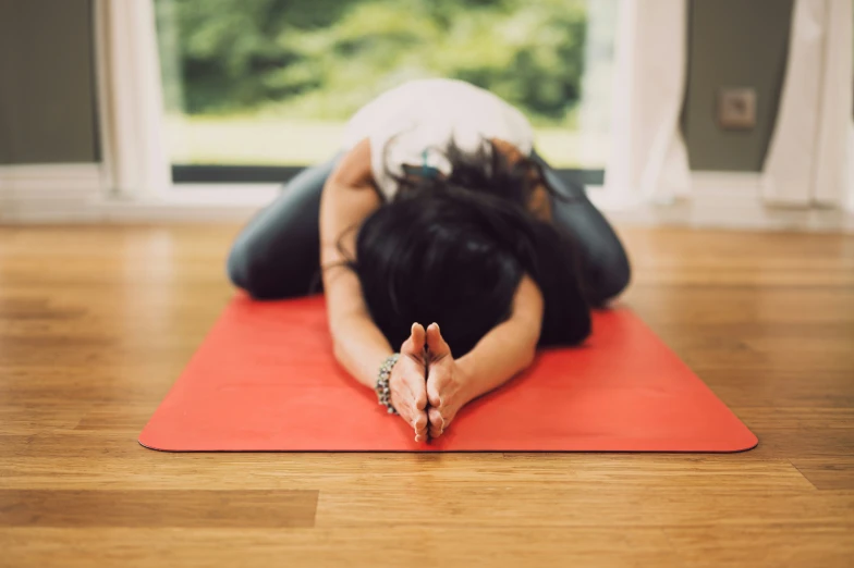 a woman is laying down on a yoga mat