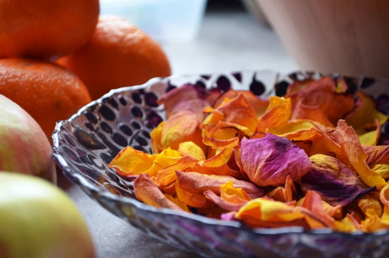 this is a bowl full of flowers and oranges