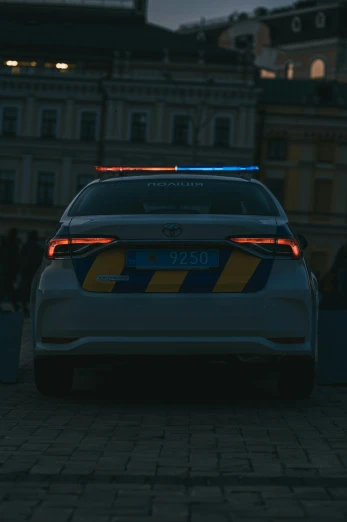 the back end of a white and blue police car