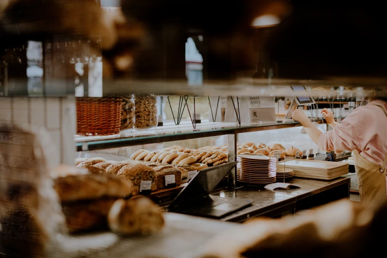 a man standing in front of a counter filled with donuts