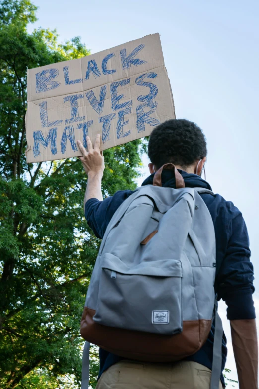 a person with a sign that reads black lives matter