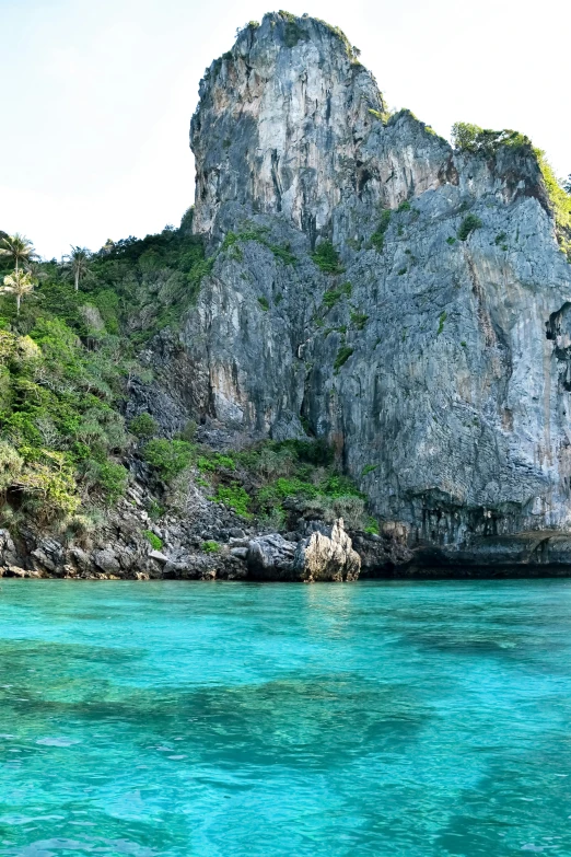 a large rocky cliff near the water near rocks