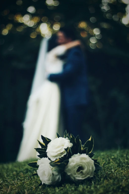 a bride and groom in front of a tree, close to each other