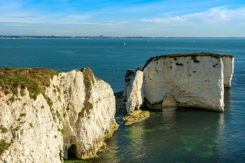 a rock formation on the edge of a bay with a steep cliff sticking out of it