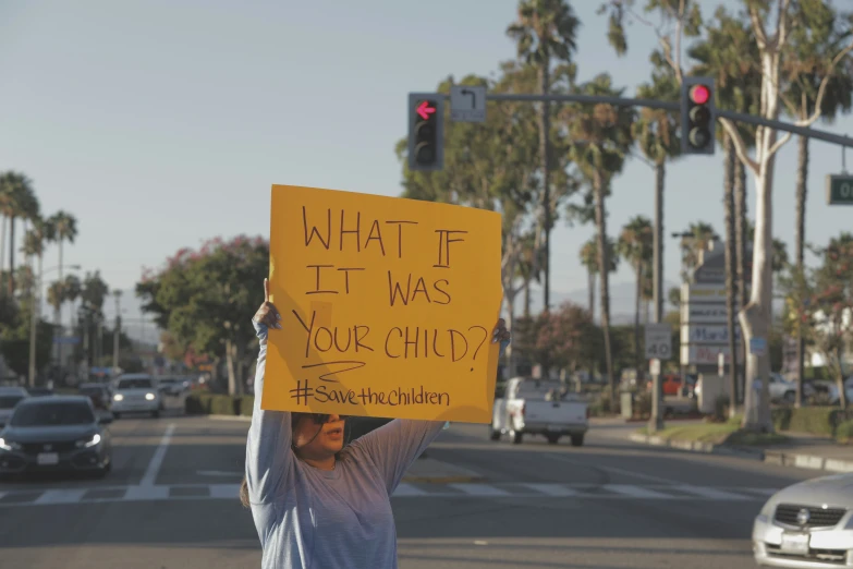 a protester holding up a sign in the street