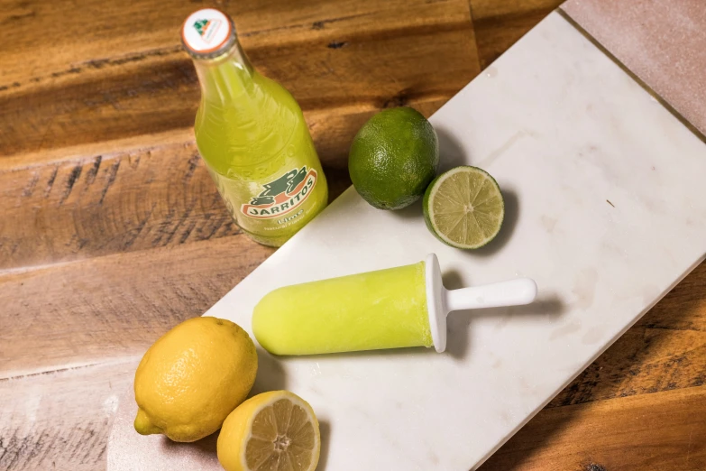 a bottle and sliced lemons sit on a  board