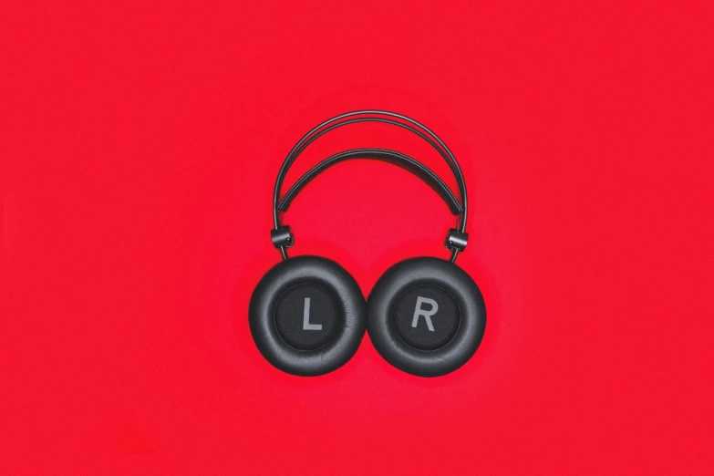 a pair of headphones resting on a red background