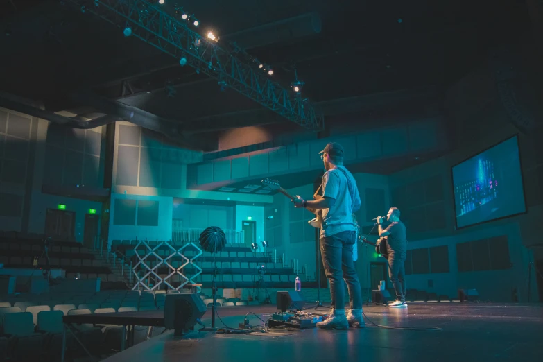 two men are playing instruments in a darkened room