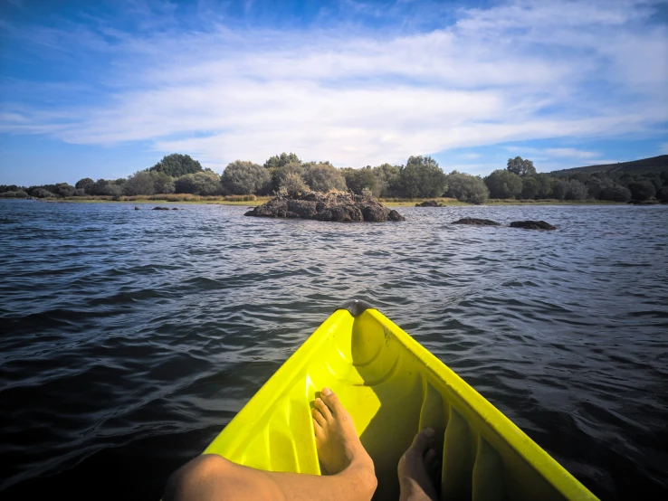 a person rowing a yellow canoe down a river