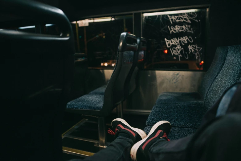 two feet are seen resting on a bench inside the vehicle