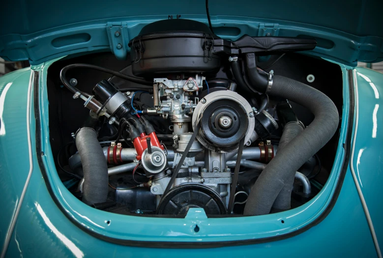 the engine of an old blue car that has been repaired