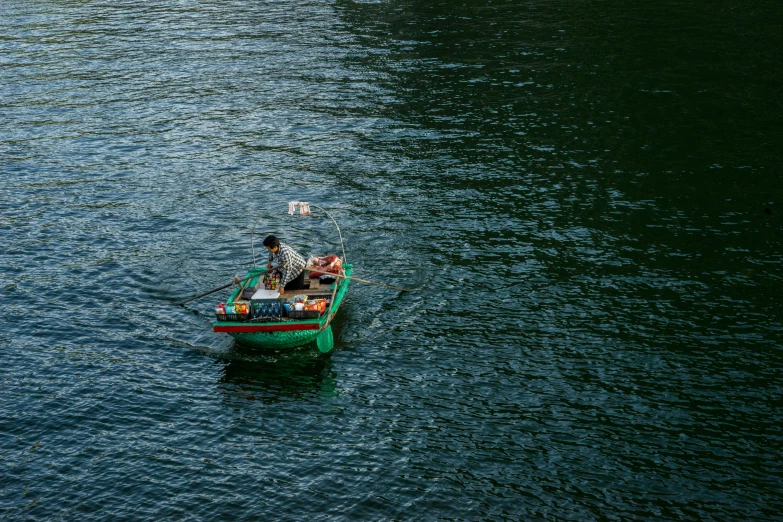 two people in a small green boat on the water