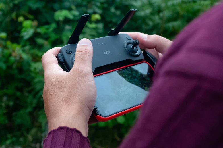 a close up of a person holding a phone with a camera attached to it