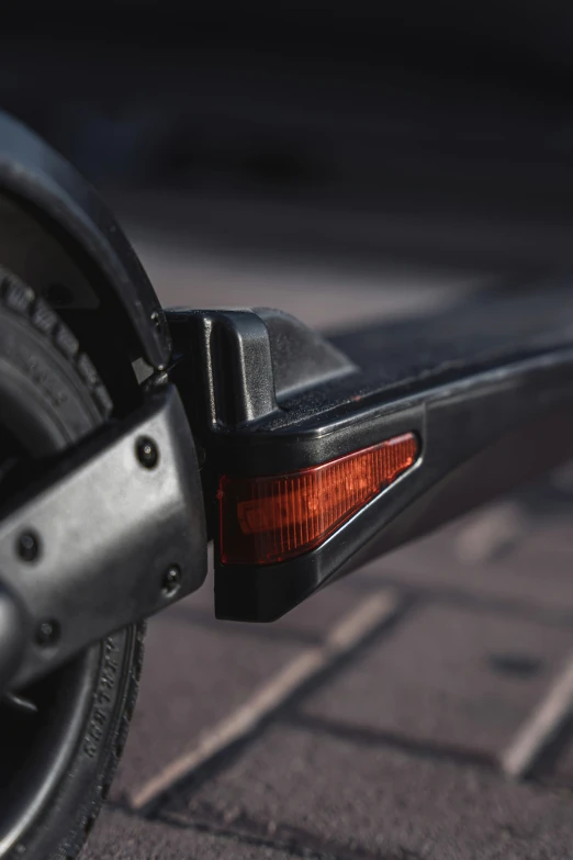 the tail light on a motor bike with a black tire