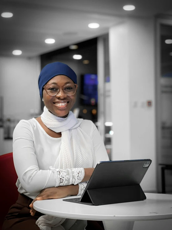 a smiling woman sitting with a laptop on her lap