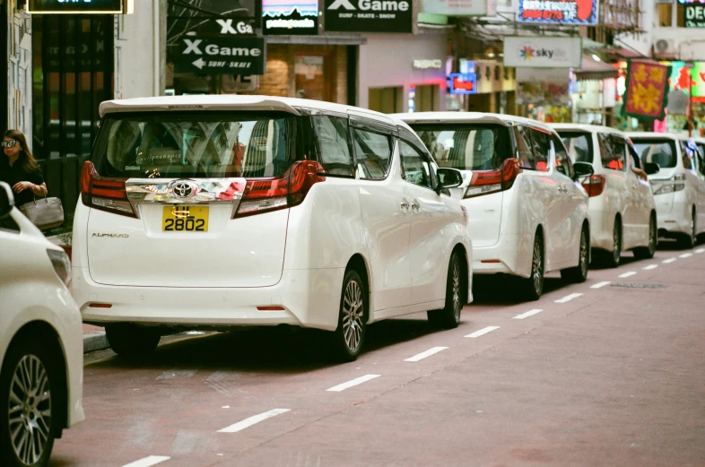 a city street lined with white mini - vans on both sides