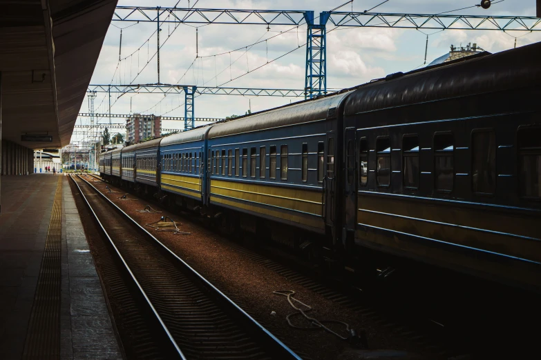 a train engine and its carts stopped at the station