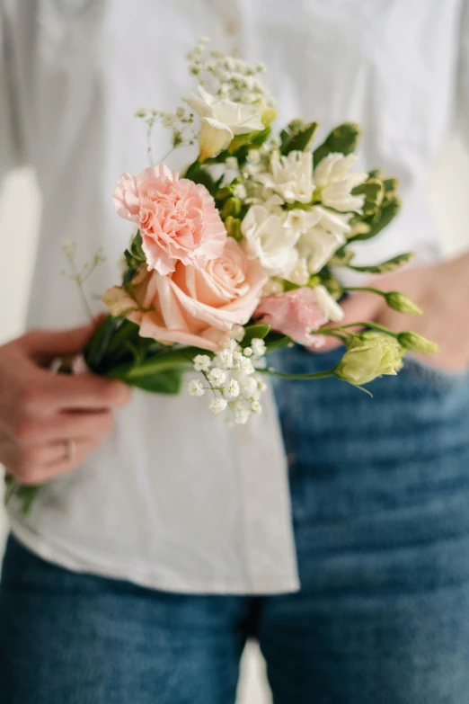 a person holding a bouquet of flowers near their waist