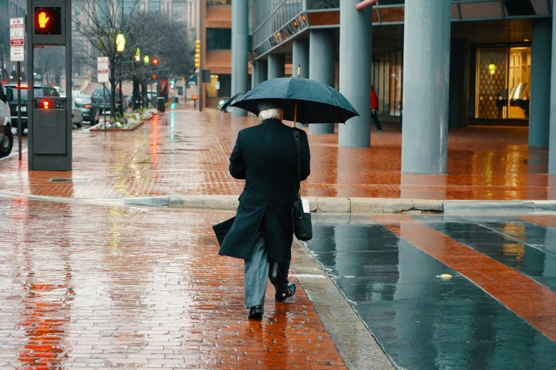 two people in a city street holding umbrellas