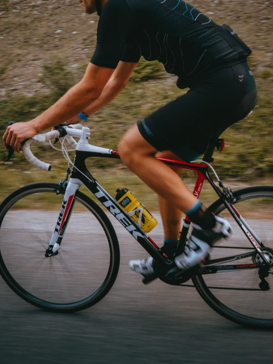 a male biker is riding a black and white bike