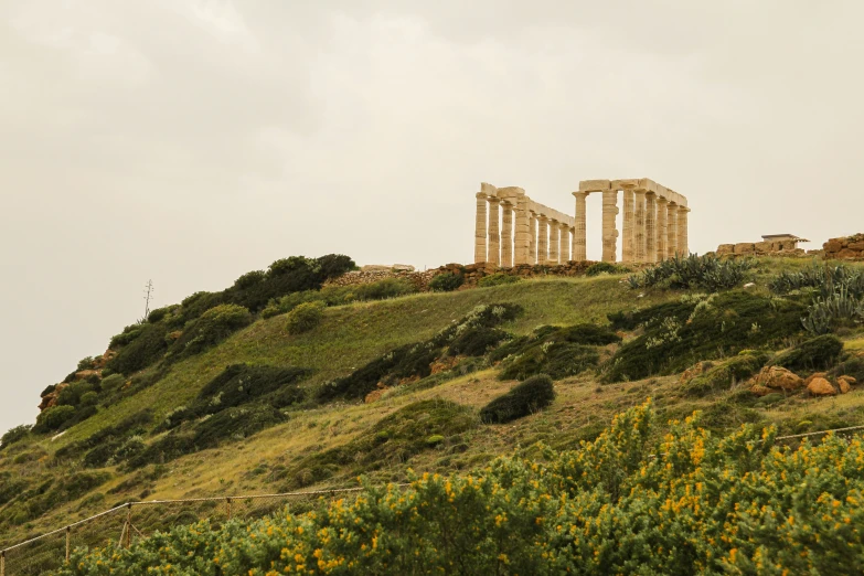 a very large building on the top of a green hill