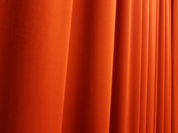 an orange sheet curtain with some lines showing it's folds