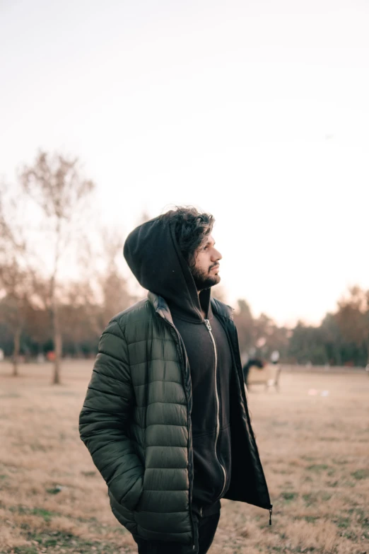 a person in a jacket standing on the grass