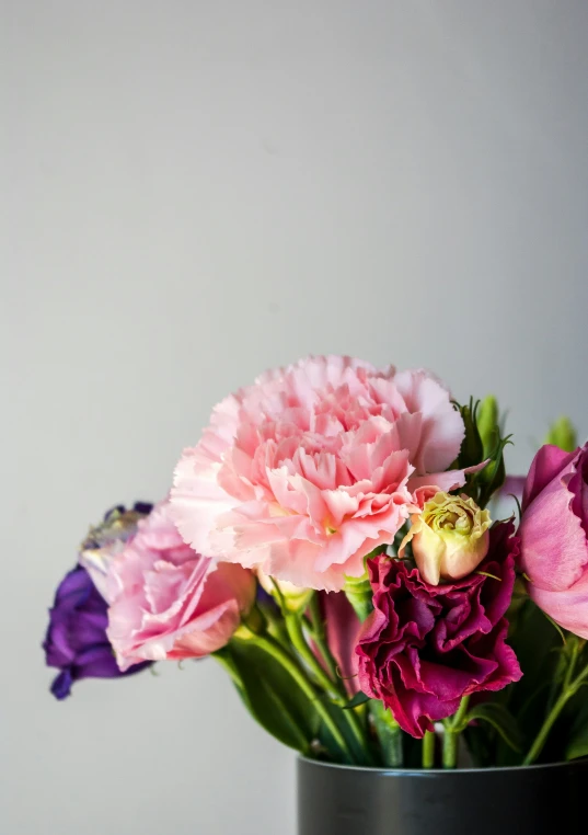 a vase filled with colorful flowers on a white table