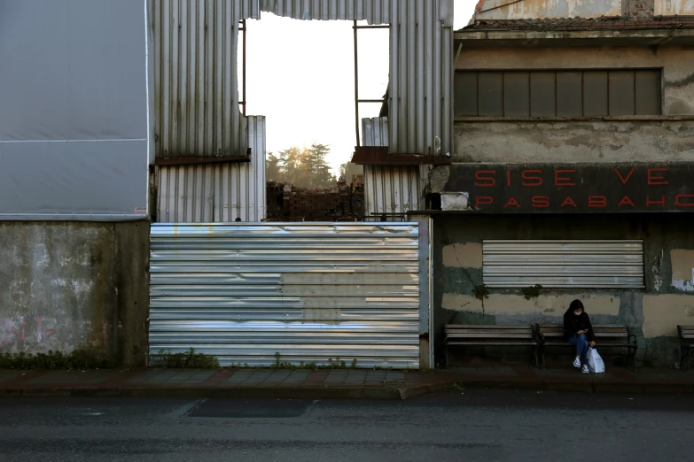 two people are sitting on a bench near a building