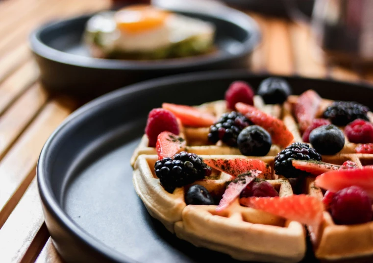 an image of a plate of waffles with fruit on them