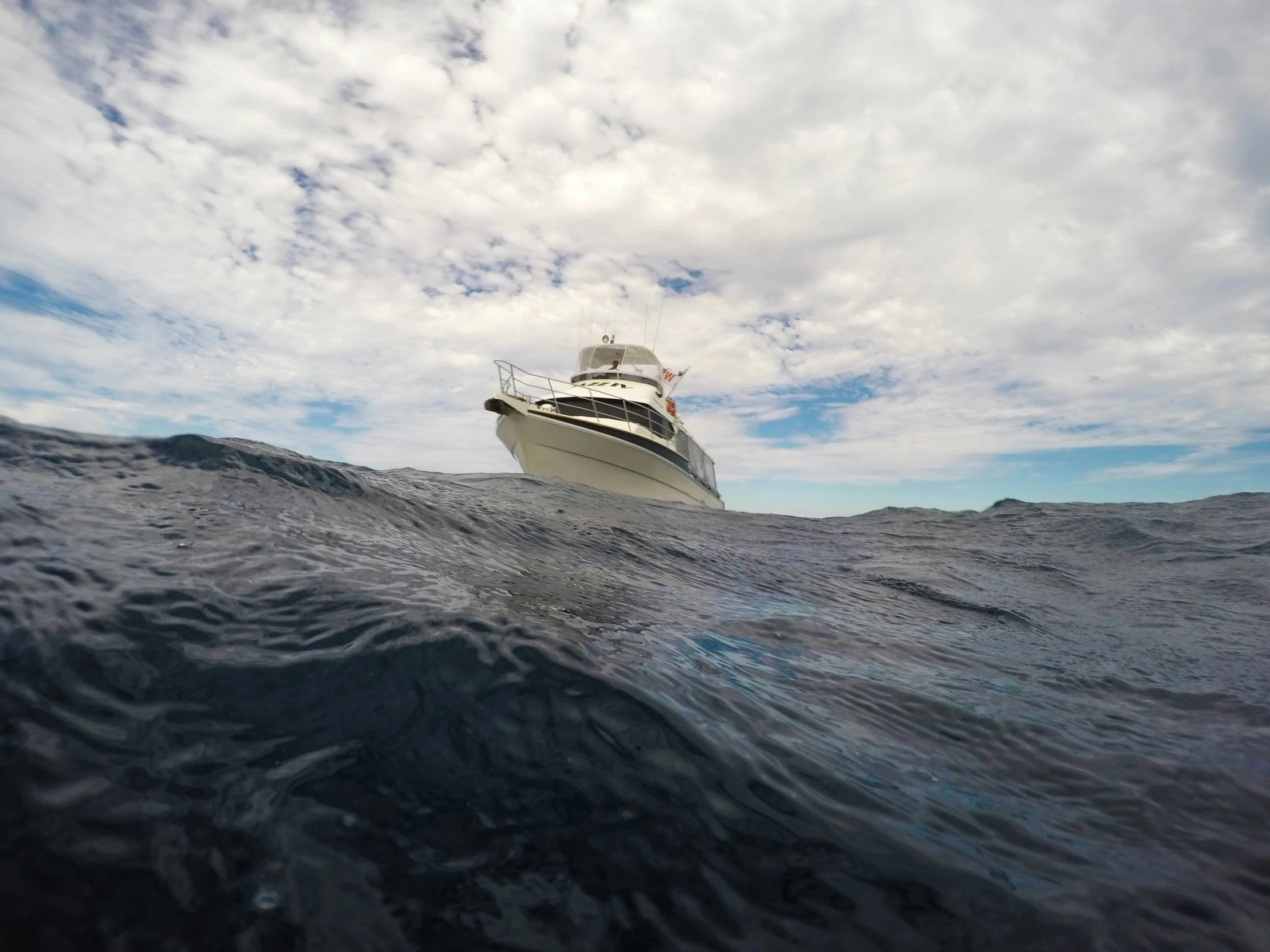 a boat sailing in the ocean on a cloudy day