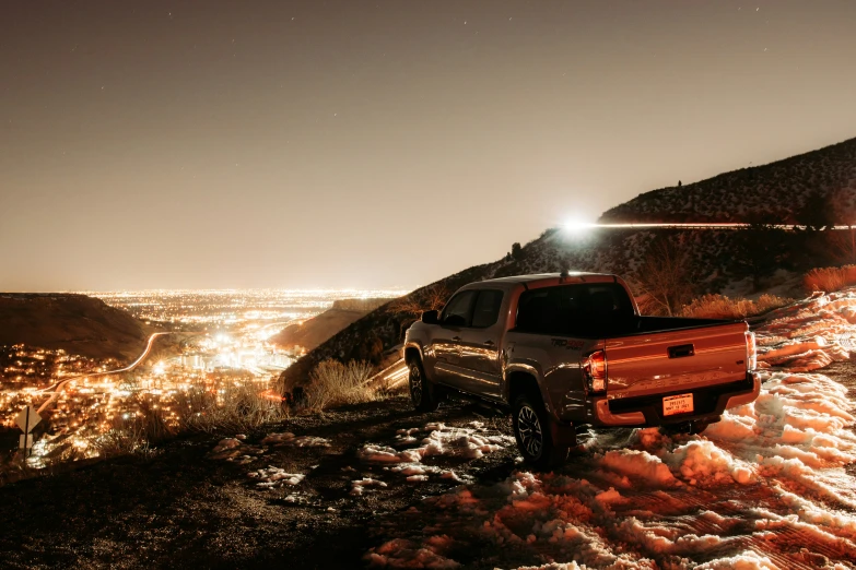 two trucks parked on top of a snow covered mountain