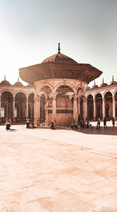 a couple of people walking around a large open courtyard